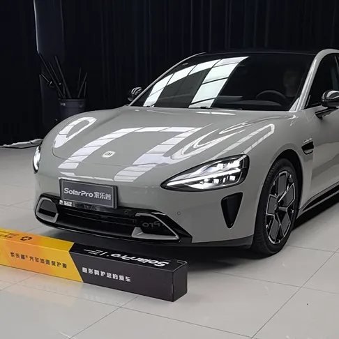 Grey electric sedan in a showroom next to a SolarPro paint protection film carton