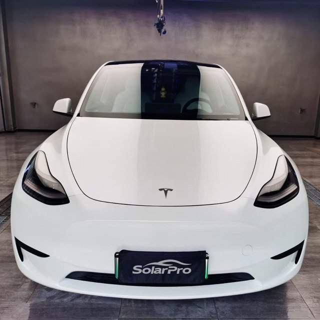 White electric crossover finished in SolarPro clear PPF, with a SolarPro plate