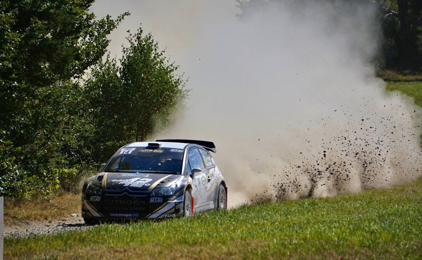 Rally car throwing up gravel on a dirt stage