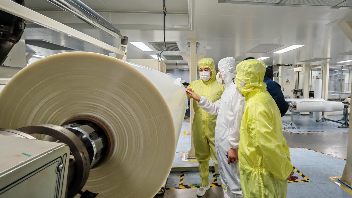 SolarPro engineers inspecting a roll of paint protection film in the clean room