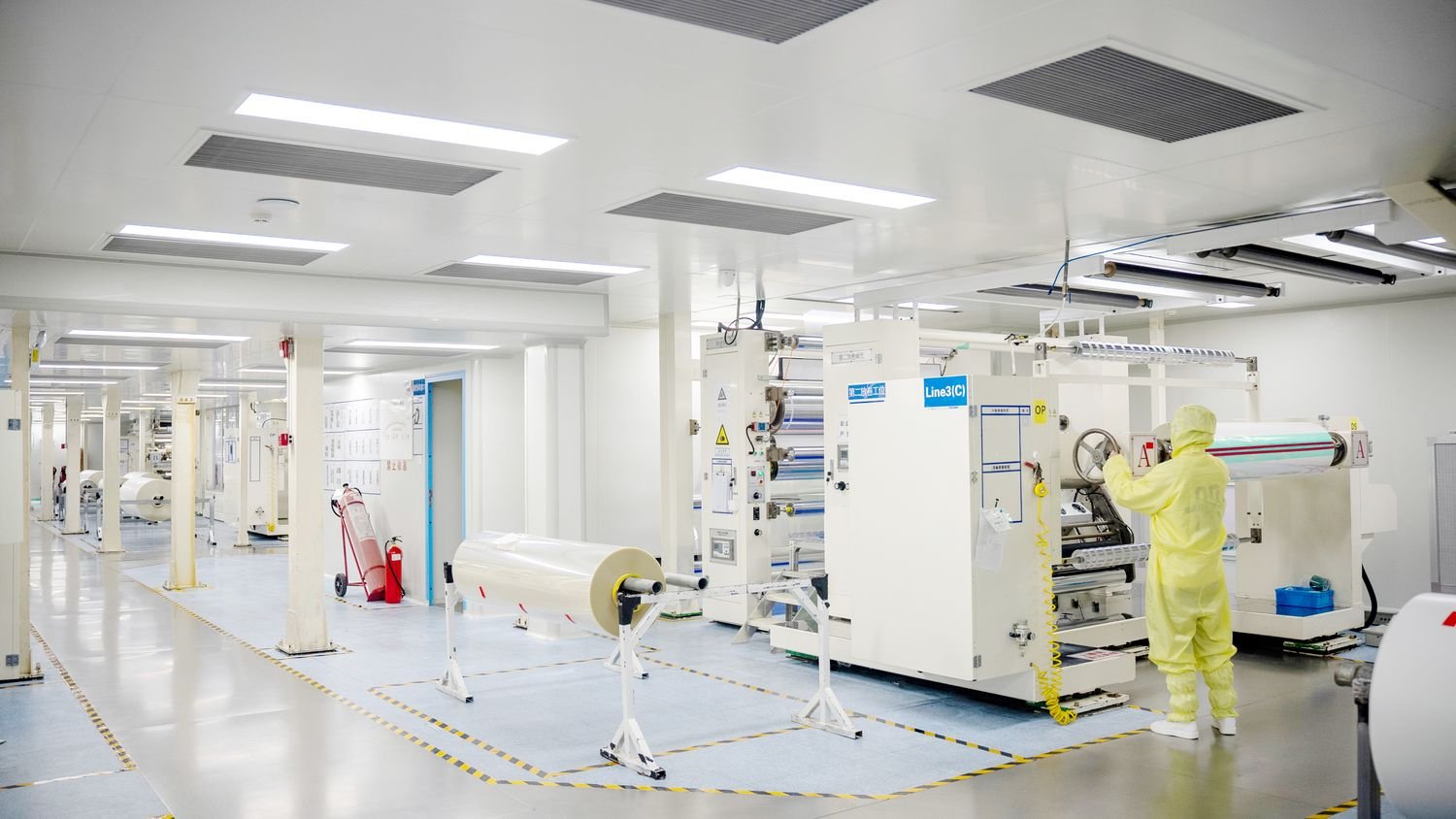 Coating hall with the web running between drying ovens