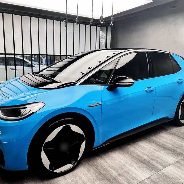 Sky-blue hatchback with a black roof in an install bay