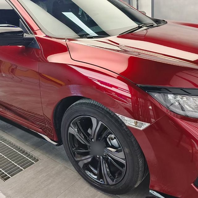 Front wing and wheel arch of a red compact car after installation
