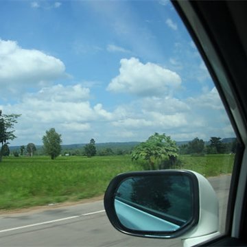 View out through a car side window past the door mirror